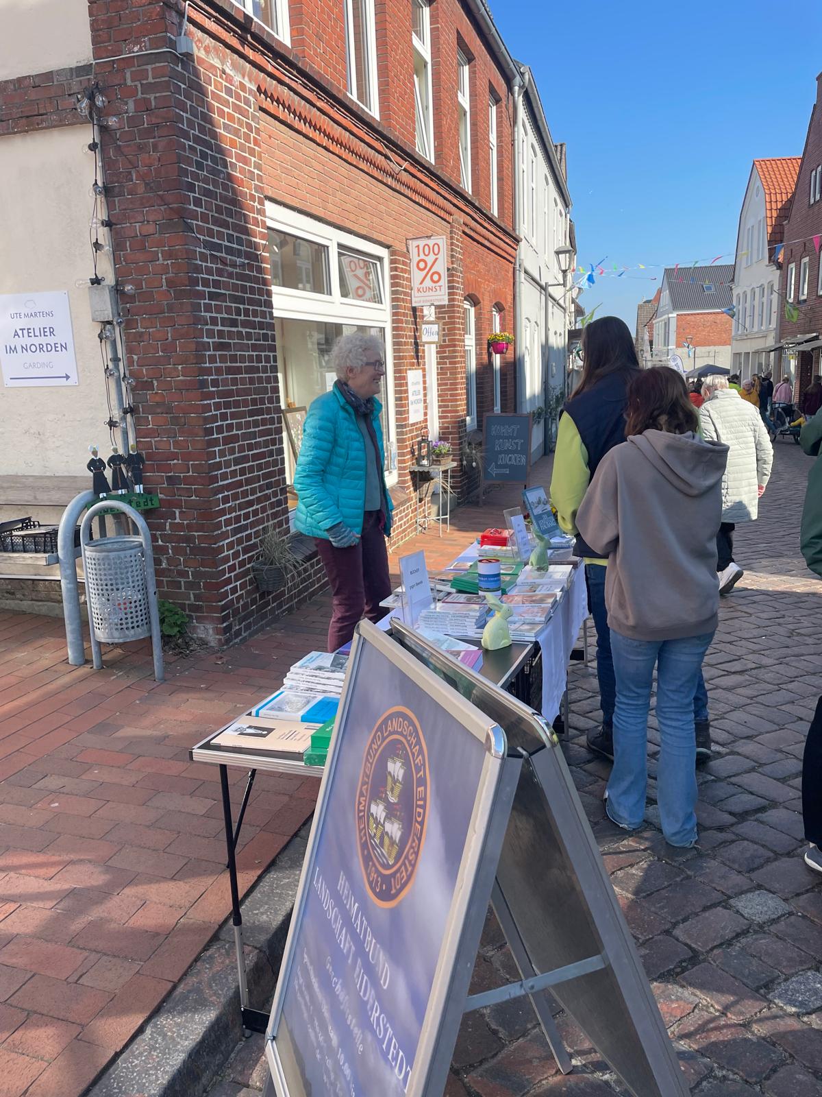 Marianne Ehlers am B&uuml;chertisch vor dem Kulturhaus/Stallerhaus im 
	Gespr&auml;ch mit Passanten